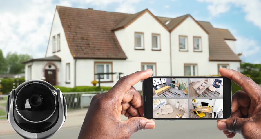 Man holding smartphone and checking footage from security cameras